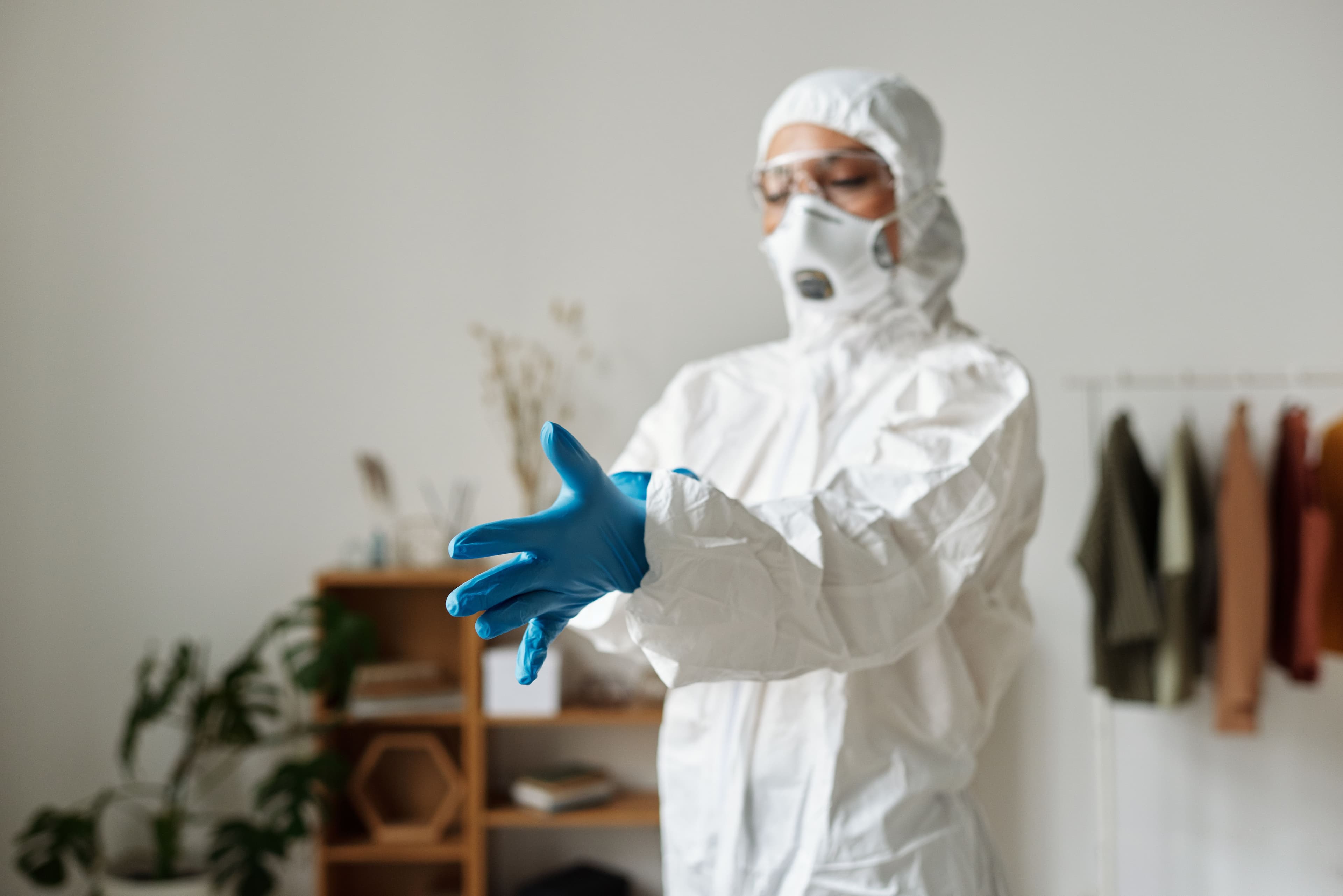 Operative wearing protective gloves preparing for a higher-risk property clean