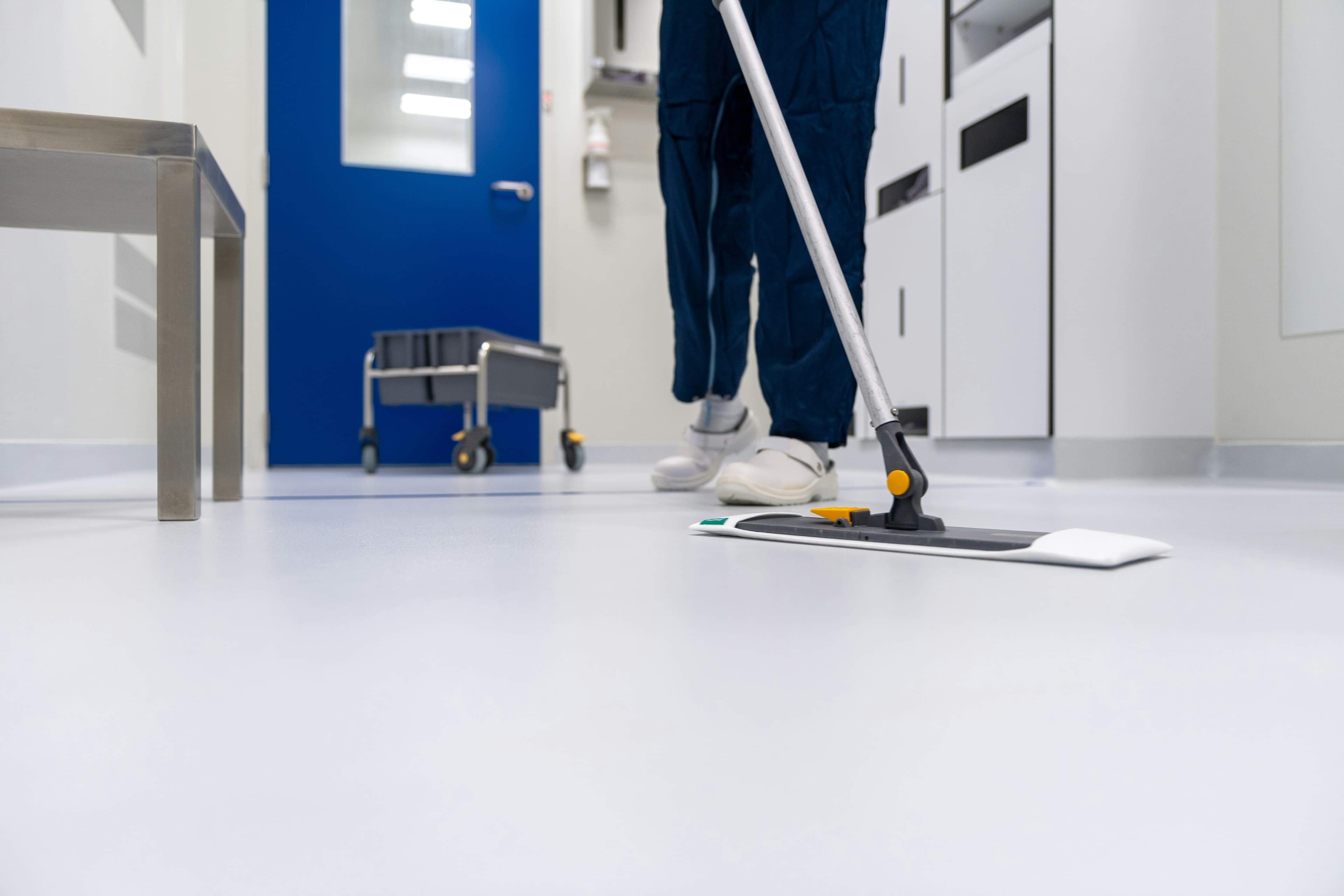 Cleaner mopping a shared corridor in a managed building
